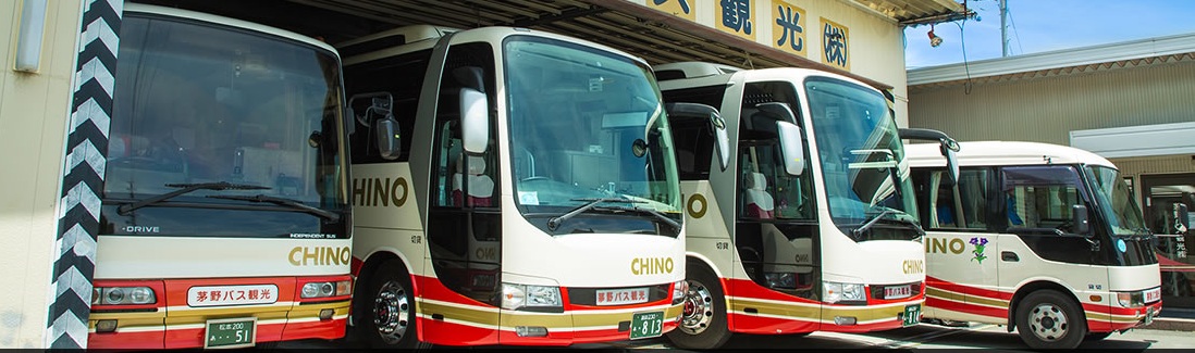 「CHINO」と表示された複数の観光バスが車庫前に並ぶ風景。団体旅行用の大型バスから送迎用の小型・中型バスまで様々なサイズの車両