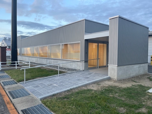 松本空港に新設された入国審査等を行うCIQ施設。グレーの外壁と大きなガラス窓が特徴のモダンな平屋建築