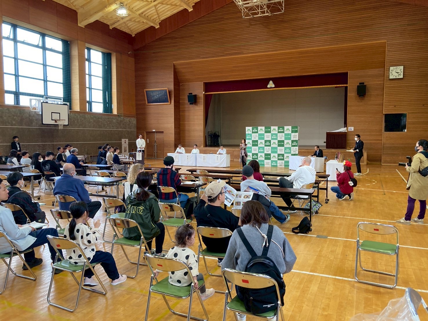 体育館のような施設で一般観覧者が椅子に座っている会場の様子